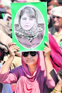 Loyalty banner: A PDP worker holds Mehbooba Muftis poster at the rally.
