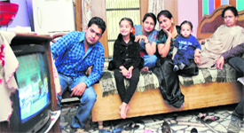 A family glued to their television set at their residence in Patiala on Monday.