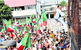 A UKD (Panwar group) worker scales a barricade near the Assembly building in Dehradun on Monday.