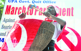 A Left party activist beats a drum during a protest against the UPA government's alleged failure to check corruption and price rise of essential commodities, in Parliament Street, New Delhi, on Monday.