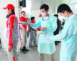 Technicians scan Red Cross rescue workers for signs of radiation in Nagahama City in northern Japan on Monday.