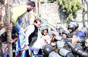 Uttarakhand Congress chief Yashpal Arya breaks a police barricade during a gherao of the state Assembly by Congress workers in Dehradun