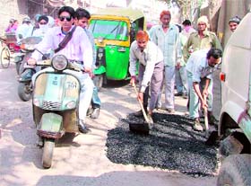 Civic employees carry out patchwork during peak hours on Arya School road.