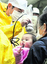 A baby is checked for radiation exposure level in Nihonmatsu in Fukushima on Tuesday. 