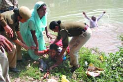 AIE Teachers Union president Swarna Devi is pulled out from the Sirhind canal on Wednesday after she jumped into it to stage protest against the state governments failure to grant them admission to the ETT course.