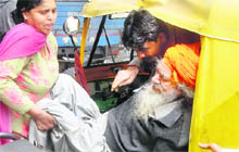 A woman helps her father on to a trolley at Government Multi-Speciality Hospital, Sector 16, Chandigarh, on Wednesday. 