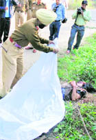 A policeman covers the body of a victim found at Sukhna Lake in Chandigarh on Wednesday.