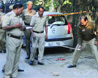 Delhi police personnel inspect the site where two persons, Shaumiddin and Rohit, were allegedly injured after a shootout in the Safderjung area of