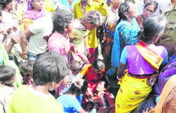 A man falls unconscious during a protest by slum-dwellers on the national highway in Sirsa