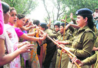 Members of women organisations scuffle with policewomen on their way to Uttarakhand Chief Ministers residence in Dehradun on Thursday.