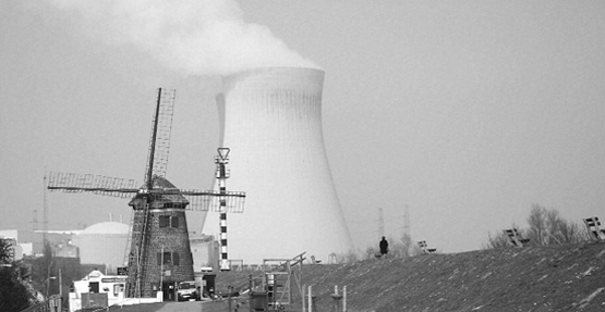 A nuclear cooling tower is seen next to a historical windmill in Doel, Belgium