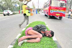 A man lies unconscious at a road divider in Jammu on Thursday.