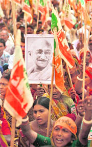 A farmer holds a portrait of Mahatma Gandhi during a protest against government's industrialisation policies at Gandhinagar on Thursday.