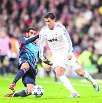 Real Madrids Cristiano Ronaldo (R) vies with Lyons Lisandro in Madrid on Wednesday.  AFP