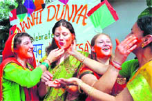 Foreigners and teachers apply gulal to each other at a function at the Nanhi Duniya school in Dehradun on Friday. 