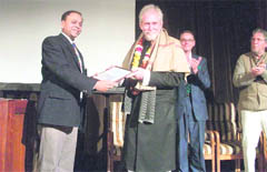 Thomas Chandy, president of the board of directors of Woodstock School, presents the distinguished alumnus award to Tom Alter in Mussoorie on Thursday.