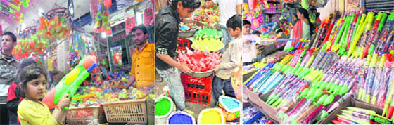 A girl tries her hand at a water gun at a shop in Jammu; Holi colours being put up at a stall; and a wide range of Holi merchandise on display.