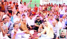 Shopkeepers in Janakpuri stage a dharna in protest against District Health Officer Dr Jagpal Singh (inset).