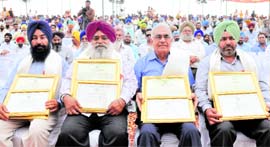 Iqbal Singh Sidhu, Surjeet Singh, Surinder Kumar Ahuja and Gurpreet Singh, who were honoured with the Chief Ministers award, at the kisan mela in PAU on Friday.