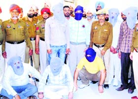 Arrested members (with covered faces) of the gang in Amritsar