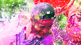 A youth tries to ward off water being thrown on him during Holi celebrations in Ludhiana on Saturday.