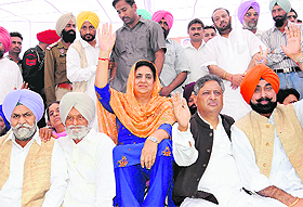 Rajinder Kaur Bhattal (centre) waves to the crowd at the Congress political conference.