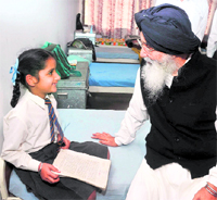 Punjab Chief Minister Parkash Singh Badal talks to a student during his visit to Sri Dasmesh Acedemy at Anandpur Sahib on Saturday.