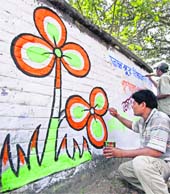 Trinamool Congress workers paint a graffiti ahead of the state Assembly elections, in Birbhum district of West Bengal on Monday.