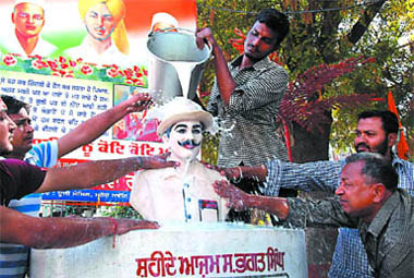 Volunteers of an NGO wash the statue of Bhagat Singh with milk on the eve of his martyrdom day in Bathinda on Tuesday.