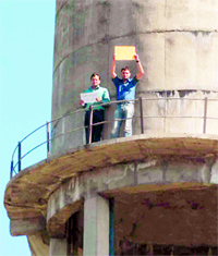 Two members of the Joint Front Teachers Union stand on the top of the water tank to mark their protest at the Landra-Kharar road in Kharar on Tuesday