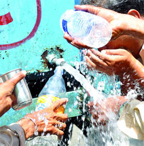 Pedestrian fill water bottles from a government tanker on the occasion of World Water Day in New Delhi on Tuesday.