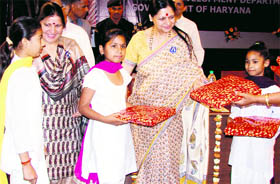 Vice-president of the Haryana Child Welfare Council Asha Hooda gives away gifts to children at the launch of the Rajiv Gandhi Kishori Sashaktikaran Scheme "Sabla" in Rohtak on Tuesday.