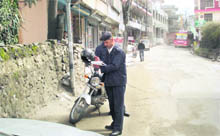 A traffic cop challans a vehicle parked on the road near Kullu Valley Hospital.