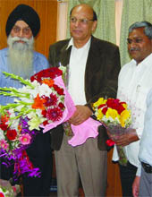 Members of the reconstituted Delhi Minority Commission, Pushpinder Singh (L) and Michal Antony (R), welcome Safdar H. Khan (C) who joins the commission as the chairman in New Delhi on Wednesday.