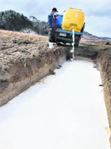 A farmer drains milk into a pit in Iitate, Fukushima, on Wednesday.