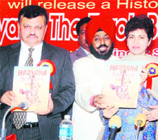 Kumari Selja, Union Minister, and Ramindra Jakhu (left), Financial Commissioner, release Tejinder Singh Walias (centre) book Haryana The Torch Bearer of 1857 