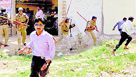Police personnel chase protesters during a demolition drive near Palam Vihar in Gurgaon on Friday.