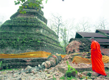 A Buddhist monk looks at a damaged pagoda after an earthquake at Wat Chedi Laung, north of Bangkok, on Friday