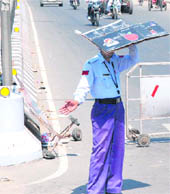 As the mercury soars, a policeman uses a piece of cardboard to protect himself from the sun while directing traffic near Government Rajindra College in Bathinda on Saturday.