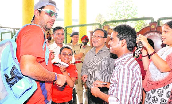 BATTING PRINCE: (Left) Fans surround Yuvraj for an autograph; and (right) a police personnel conducts checks in a Punjab Roadways bus at Sector 39, Chandigarh