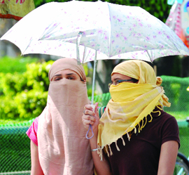 Girls protect themselves from the heat at Connaught Place in 