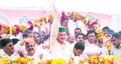 MP Birender Singh waives at the crowd at a meeting in Uchana in Jind 