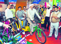 A rickshaw puller checks out gears and shockers of a rickshaw