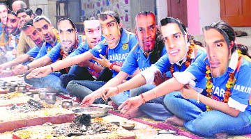 Members of the Gurukul Vidyapeeth cricket fan club perform a havan wearing masks of Indian cricket players at a mandir in Sector 23, Chandigarh on Monday. 