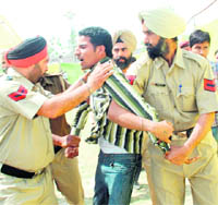 A member of the Unemployed Physical Training Instructors (PTI) Teachers Union, who protested against Harsimrat Badal during the function, being taken away by the police in Phagwara on Monday. 