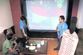 Cricket enthusiasts enjoy drinks while watching a game at a hotel in Ludhiana