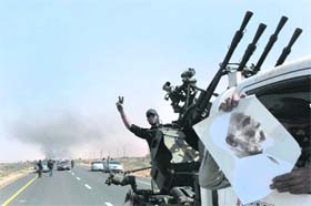 Libyan rebels ride in their vehicles on their way to Muammar Gaddafi's home town of Sirte