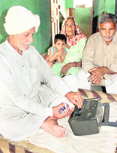 An old farmer dusts his transistor and replaces its old batteries to listen to the commentary of the Indo-Pak World Cup semi-final match to be played on Wednesday, at Sundana village in Rohtak district on Tuesday.