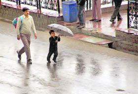 A child holds an umbrella during a rain in Shimla on Tuesday.