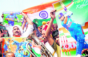 Cricket enthusiasts hold a poster of Indian cricket players in Jammu on Tuesday